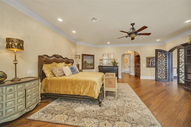 bedroom featuring ceiling fan, ornamental molding, and dark hardwood / wood-style flooring