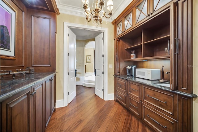 interior space featuring a notable chandelier, sink, hardwood / wood-style flooring, and crown molding