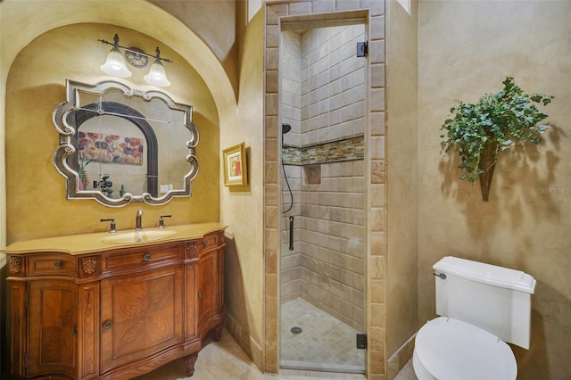 bathroom featuring vanity, toilet, and a shower with door