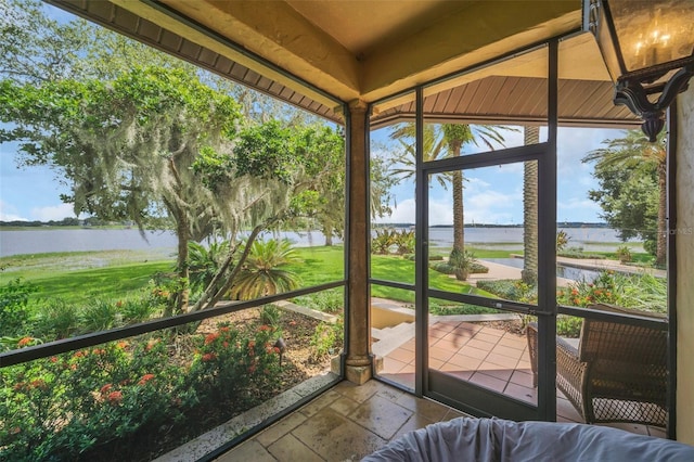 unfurnished sunroom featuring a water view