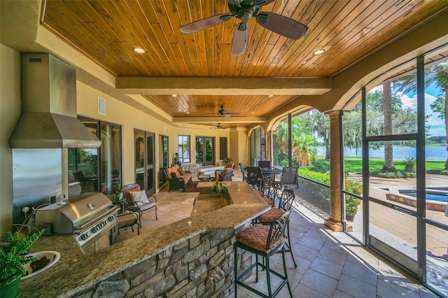 sunroom featuring wood ceiling, ceiling fan, and beamed ceiling