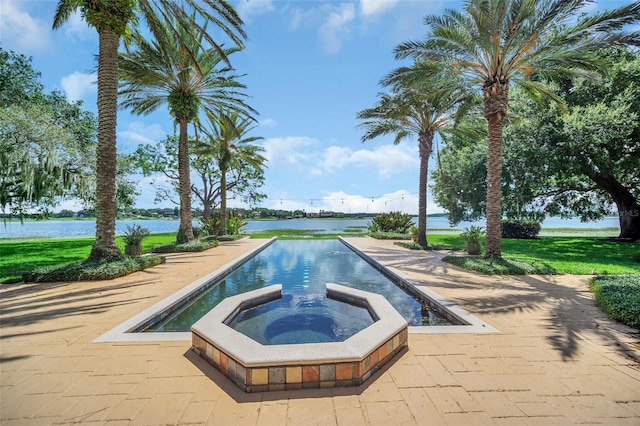 view of swimming pool with an in ground hot tub, a water view, and a patio area