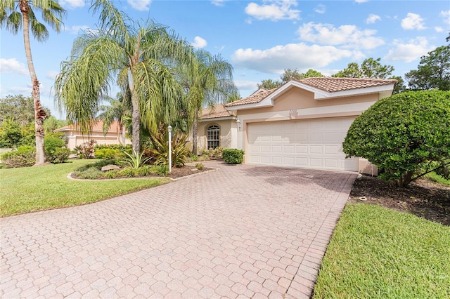 mediterranean / spanish home with a front lawn and a garage