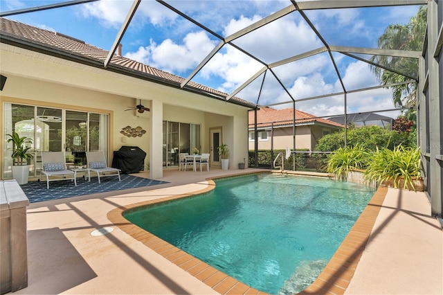 view of pool featuring grilling area, a patio area, glass enclosure, and ceiling fan