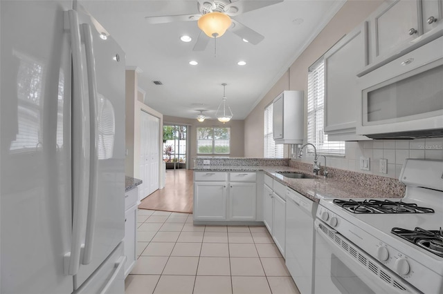 kitchen with white appliances, sink, tasteful backsplash, light tile patterned flooring, and white cabinetry