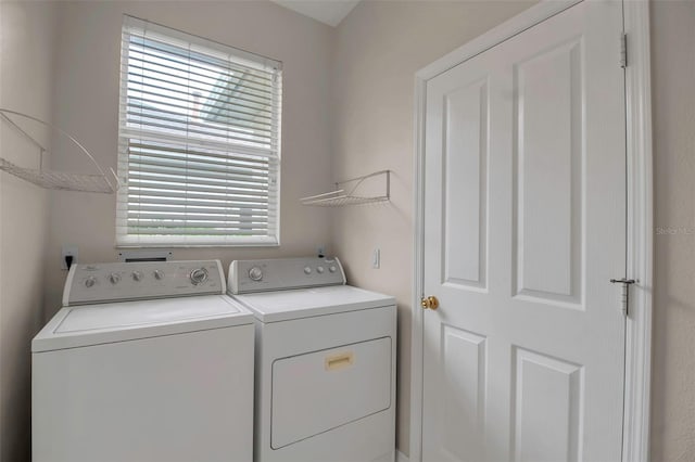 clothes washing area with separate washer and dryer