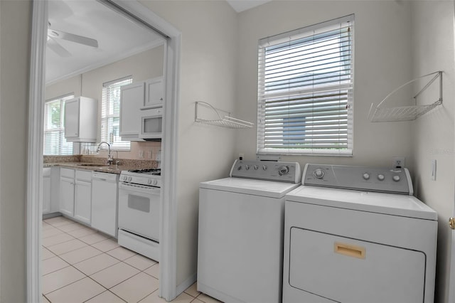 laundry area featuring sink, ceiling fan, separate washer and dryer, ornamental molding, and light tile patterned flooring