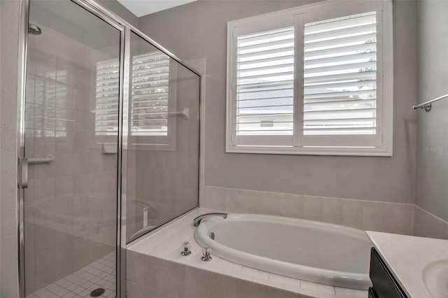 bathroom featuring shower with separate bathtub, vanity, and a wealth of natural light