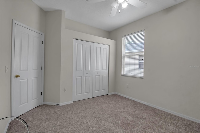 unfurnished bedroom with ceiling fan, a closet, and light colored carpet