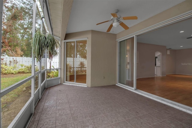 unfurnished sunroom featuring ceiling fan