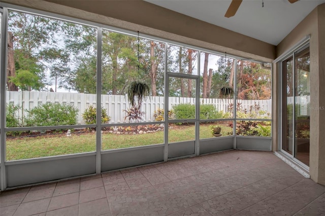 unfurnished sunroom featuring ceiling fan and a healthy amount of sunlight