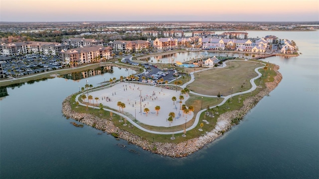 aerial view at dusk featuring a water view