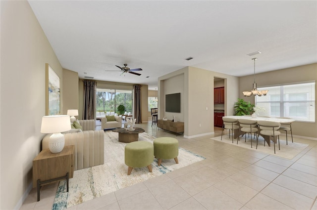 tiled living room with ceiling fan with notable chandelier