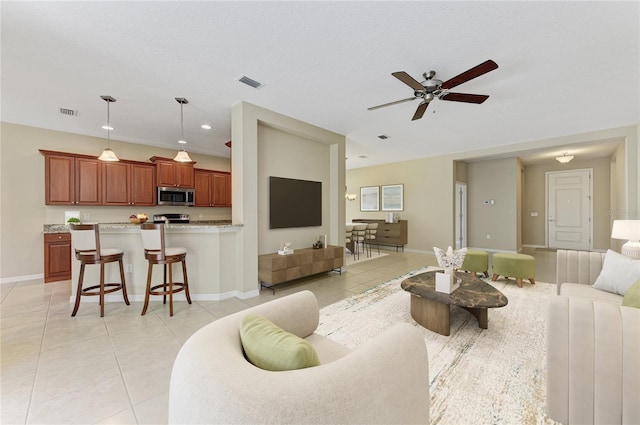 tiled living room with a textured ceiling and ceiling fan