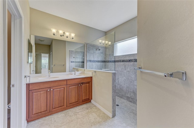 bathroom with tile patterned flooring, vanity, and tiled shower