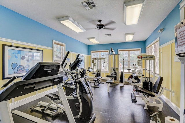 workout area with ceiling fan and a textured ceiling