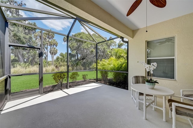 unfurnished sunroom featuring a healthy amount of sunlight and ceiling fan