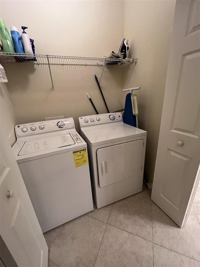 washroom featuring washing machine and clothes dryer and light tile patterned flooring