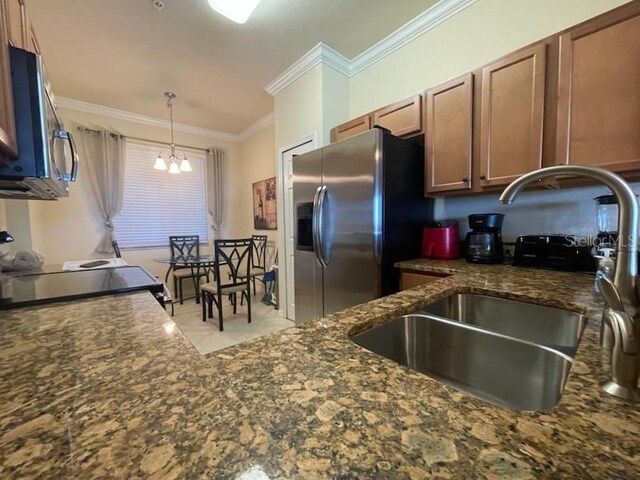 7005 River Hammock Dr Unit 404, Bradenton, FL 34212 - kitchen featuring crown molding, hanging light fixtures, a sink, an inviting chandelier, and stainless steel appliances