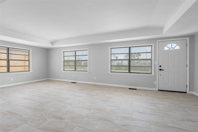 foyer entrance with a raised ceiling