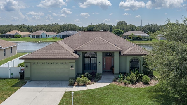 ranch-style house featuring a water view, a front yard, and a garage