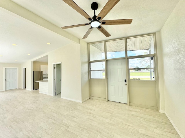 spare room featuring a textured ceiling, light hardwood / wood-style flooring, and ceiling fan