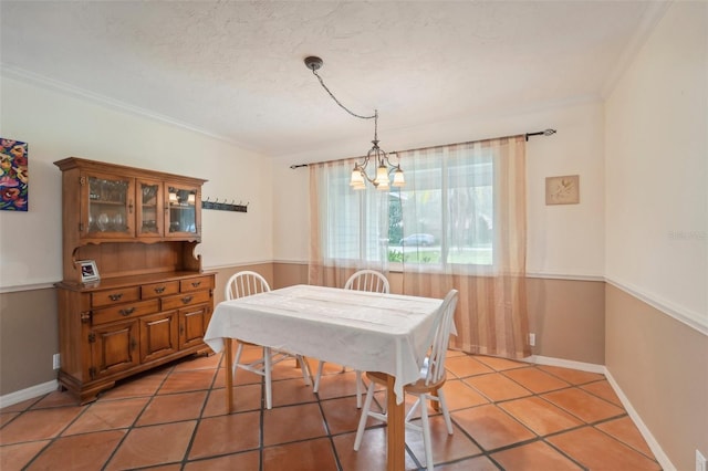 dining space featuring a notable chandelier, ornamental molding, a textured ceiling, and light tile patterned flooring