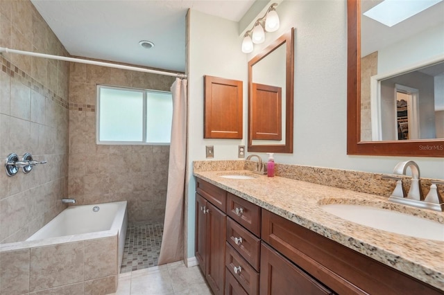 bathroom with shower with separate bathtub, vanity, a skylight, and tile patterned floors