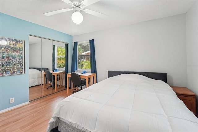 bedroom featuring ceiling fan, light hardwood / wood-style flooring, and a closet