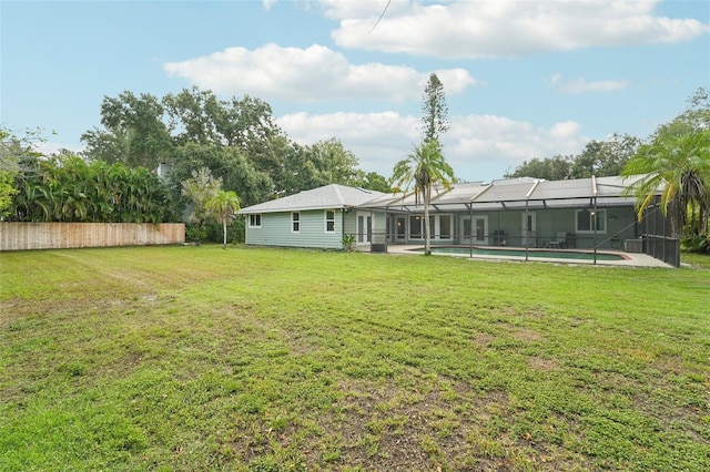 view of yard featuring a fenced in pool and glass enclosure