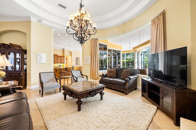 living room featuring ornamental molding, a raised ceiling, and a notable chandelier