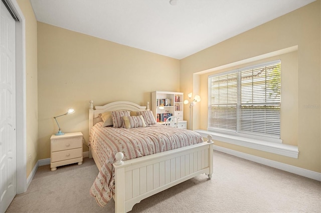 bedroom with a closet and light carpet