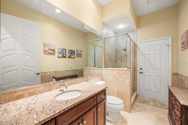 bathroom featuring toilet, an enclosed shower, tile walls, vanity, and tile patterned flooring