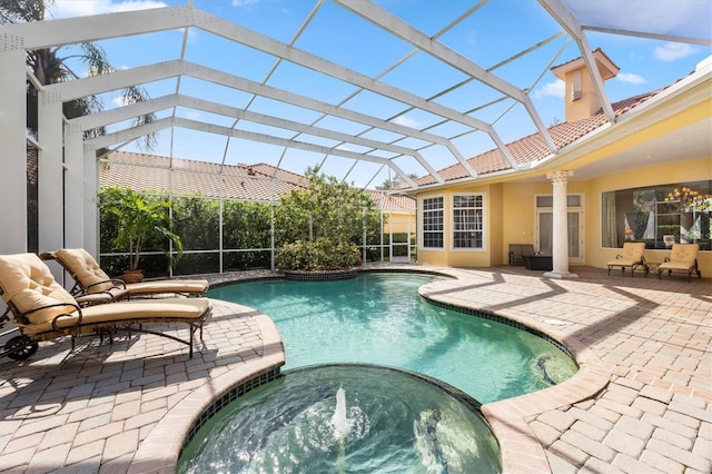 view of pool with a lanai, a patio area, and an in ground hot tub