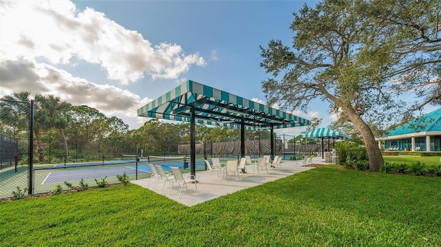 view of home's community featuring tennis court and a lawn