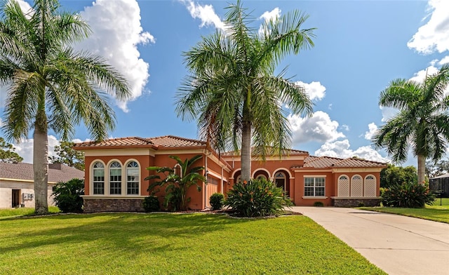 111 172nd St E, Bradenton, FL 34212 - mediterranean / spanish house with stucco siding, concrete driveway, a tiled roof, and a front yard