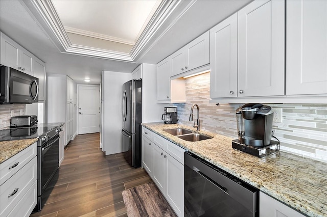 kitchen with dark wood-type flooring, white cabinets, stainless steel appliances, a tray ceiling, and sink