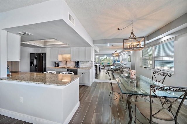 kitchen featuring black appliances, white cabinetry, and dark wood-type flooring