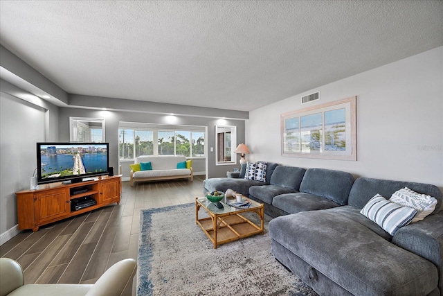 living room featuring a textured ceiling and dark hardwood / wood-style floors