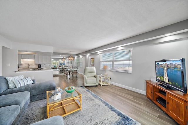 living room with light wood-type flooring and a textured ceiling