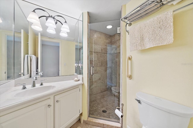 bathroom featuring a shower with door, vanity, and toilet