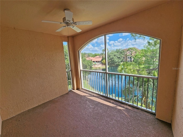 balcony with a water view and ceiling fan