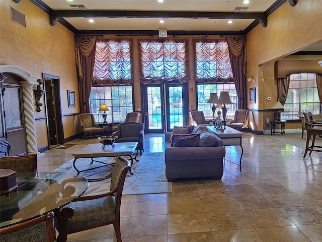 living room with tile patterned flooring, ornamental molding, a towering ceiling, and beamed ceiling