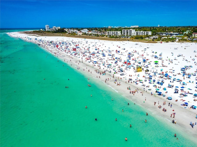 drone / aerial view featuring a water view and a view of the beach