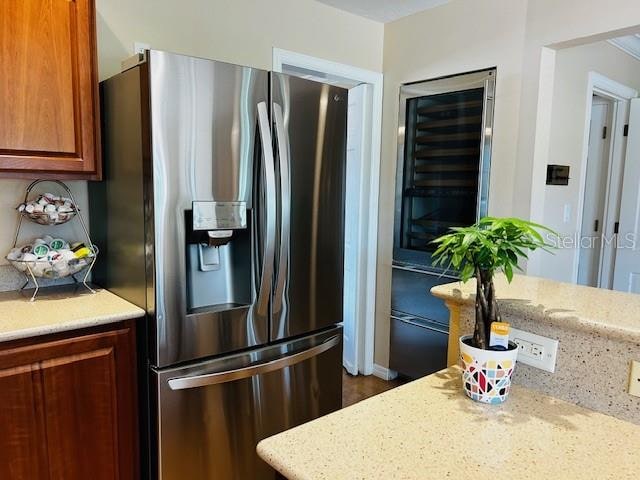 kitchen with stainless steel fridge and light stone counters