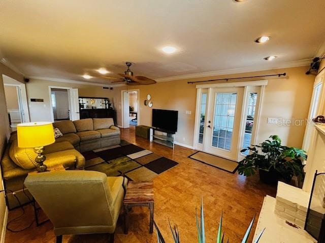 living room with ceiling fan and ornamental molding