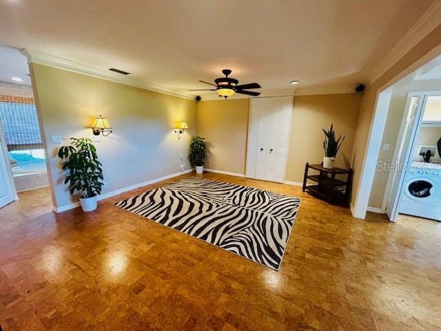 living area with ceiling fan, plenty of natural light, washer / dryer, and ornamental molding