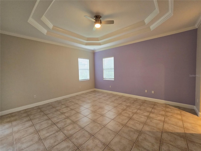 tiled empty room with ceiling fan, a raised ceiling, and crown molding