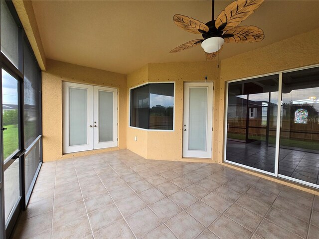 unfurnished sunroom with ceiling fan, french doors, and a wealth of natural light