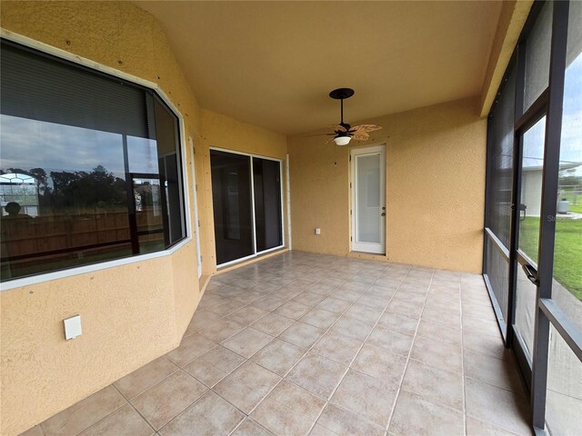 unfurnished sunroom with ceiling fan